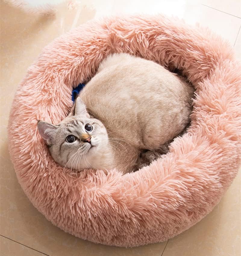 Cat bed round fluffy pink shows plush surface for curling up in cozy comfort.