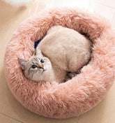 Cat bed round fluffy pink shows plush surface for curling up in cozy comfort.
