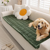 FUNNY FUZZY pet couch cover on a dark green sofa guards against scratches and pet hair.