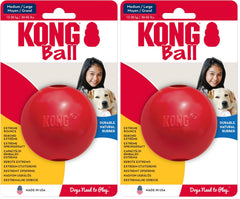 KONG Ball with Hole red fetch toy in grass for training and play.