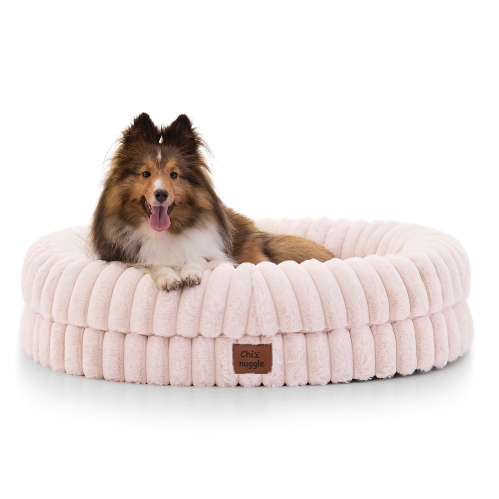 ChiXnuggle dog bed pink striped in-use scene with a sleeping pup for relaxing naps.