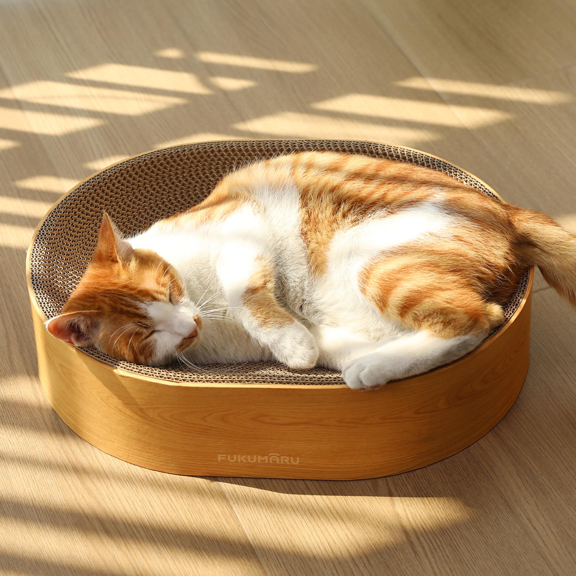FUKUMARU oval cat scratcher bed for ergonomic lounging and clawing.