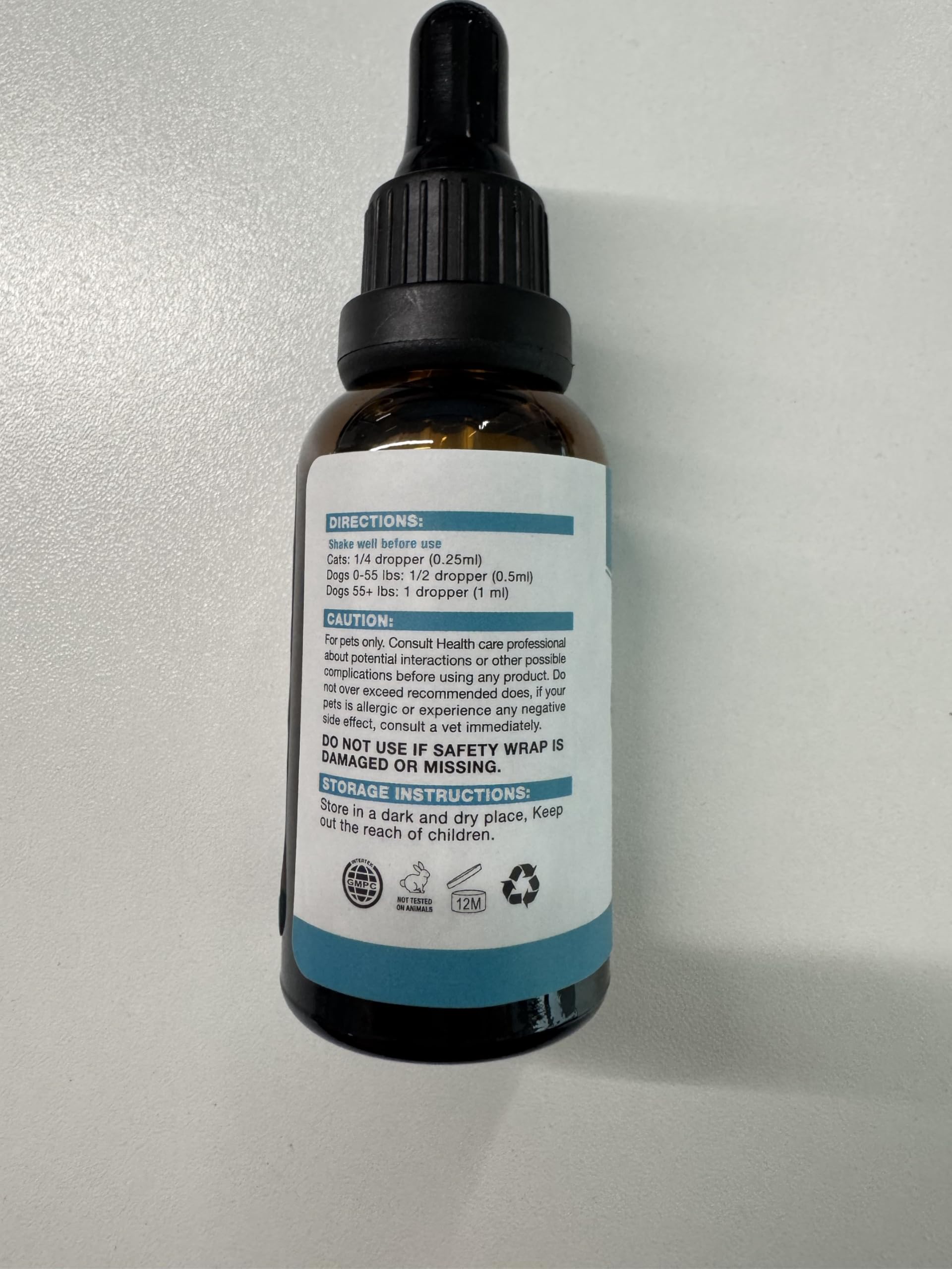 MaxHemp pet oil dropper on a cat during grooming for smoother handling.