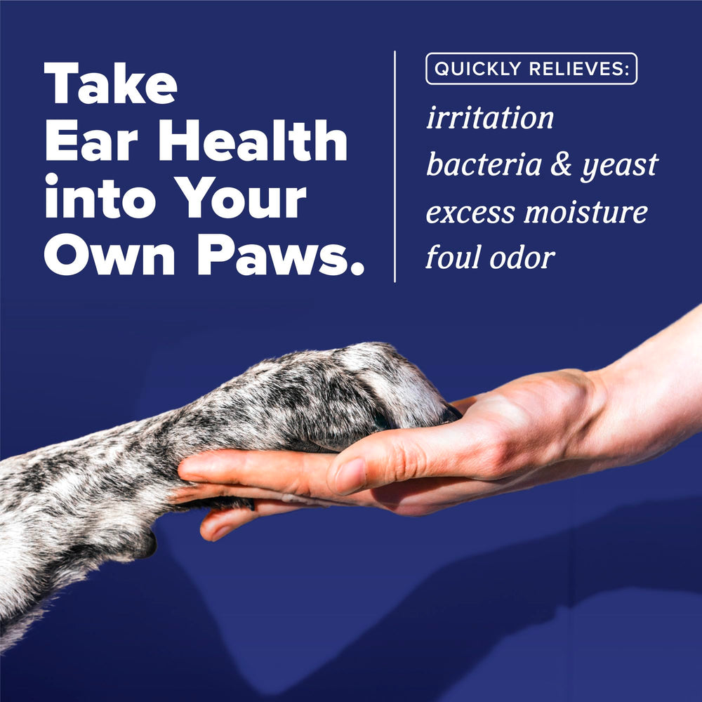TropiClean HomeVet ear drops being applied to a dog's ear for relief