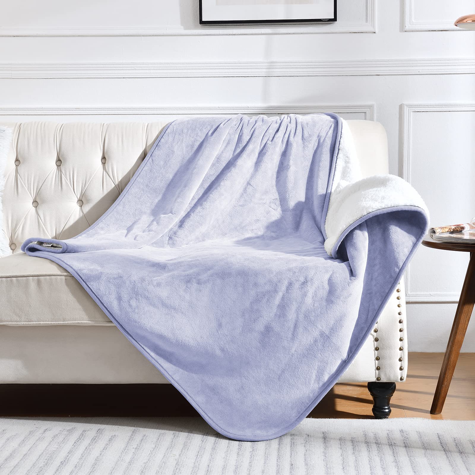 Yaning waterproof blanket on bed and couch in lilac protects furniture from spills.