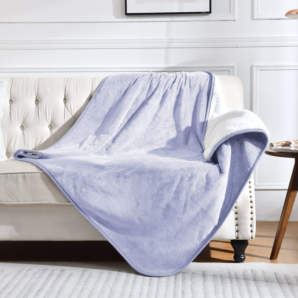 Yaning waterproof blanket on bed and couch in lilac protects furniture from spills.